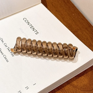 Vue macro d'un chouchou spirale ambre sur un livre montrant la texture en résine lisse