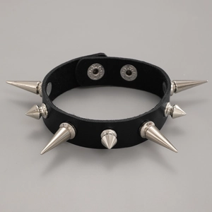 Detail eines schwarzen Leder-Punk-Armbands mit silbernen Metallspikes und Druckknöpfen