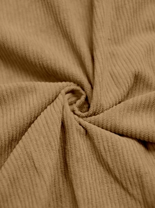 Macro detail of khaki corduroy fabric texture showing soft drape and ribbed material quality