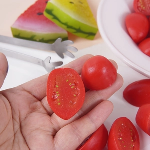 Realistic artificial cherry tomato model with sliced half and vibrant red finish
