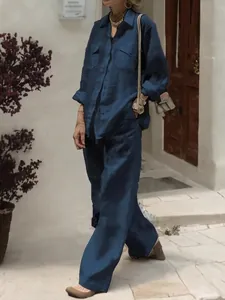 Detail of dark blue linen shirt and wide-leg trousers set with breast pockets and texture