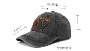 Detailed macro view showing orange BOY embroidery on vintage washed grey baseball cap fabric