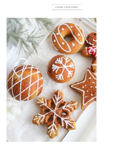 Close-up of gingerbread man and snowflake Christmas tree hanging ornaments with icing detail