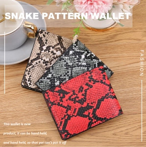 Detailed view of folded snake skin pattern wallets in red, grey-green, and light brown