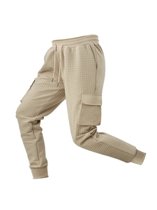 Dettaglio dei pantaloni sportivi kaki a nido d'ape con coulisse e tasca cargo