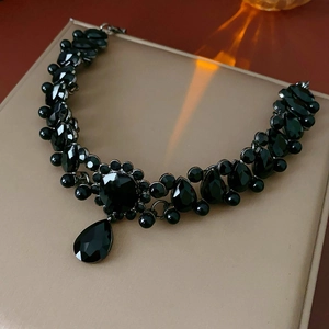 Detailed view of vintage necklace featuring faceted black gemstones and teardrop pendant