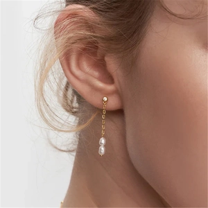 Detail of luxury S925 silver long tassel earrings with pearls on model ear