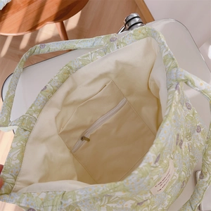 Detail of floral tote bag interior featuring functional zipper pocket and beige lining