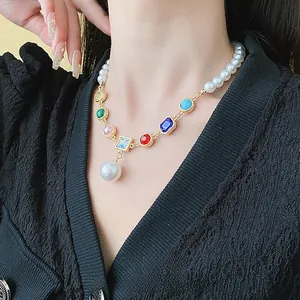 Detail of colorful gemstone and pearl beaded necklace with gold finish on model