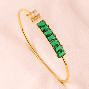 Detail van verstelbare gouden armband met rechthoekige groene stenen en witte zirkonia