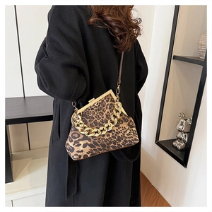 Chic leopard print shell bag with chunky gold chain strap shown on a model