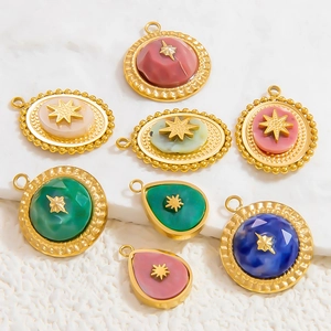 Detail view of colorful natural stone pendants with gold star inlays on white surface