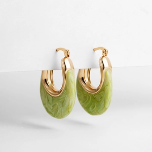 Close-up of gold-plated U-shaped earrings with green marbled enamel and polished finish