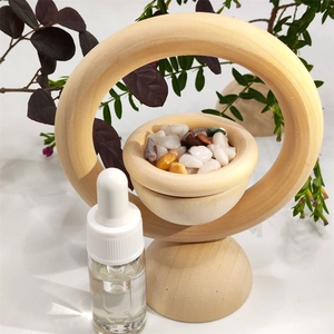 Vertical wooden diffuser ring with crystal stones and essential oil dropper on white background