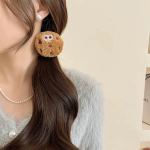 Detail of cute plush toast bread hair tie with cartoon embroidery on brown biscuit mascot
