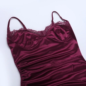 Détail de la robe en satin bordeaux avec bordure en dentelle et texture plissée
