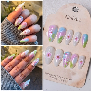 Detail of almond-shaped press-on nails with 3D floral carvings and pastel gradient finish