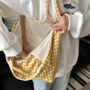 Detail view of the yellow checkered canvas tote bag interior with zipper pocket