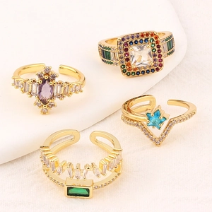 Set of four gold rings featuring square and star emerald-colored zircons on white steps