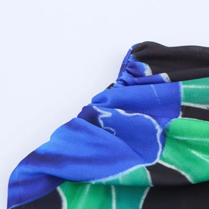 Macro detail of royal blue and emerald green floral print dress with pleated texture