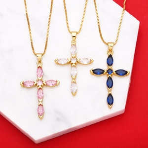 Detailed view of cross necklaces featuring pink, white, and blue cubic zirconia on gold chains