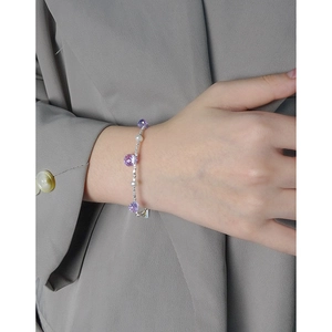 Elegant S925 silver bracelet featuring purple crystals and pearls on a woman's wrist