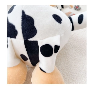 Close-up of soft plush fabric and stitching on a cow-shaped crossbody bag for kids