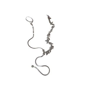 Silver snake chain finger bracelet with leaf sequin tassels on white background