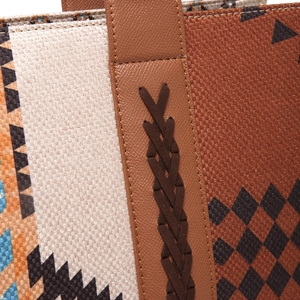 Detail of woven fabric and brown leather strap with geometric patterns on a crossbody bag