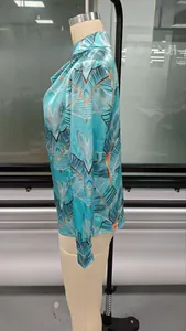 Detail of Tiffany blue satin shirt showing abstract leaf pattern and glossy silk texture