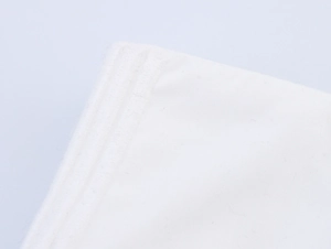 Gros plan détaillé du tissu en coton blanc avec broderie et double couture renforcée