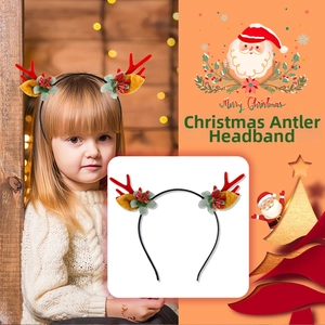 Close-up of Christmas reindeer antler headband with red berries and green leaves