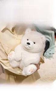 Detail of white plush teddy bear showing soft fur texture and pink embroidered paws