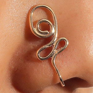 Detail of golden U-shaped non-pierced nose ring with intricate swirl design on model
