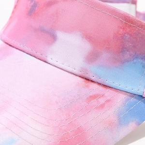 Macro detail of tie-dye visor hat showing pink and blue patterns with parallel stitching