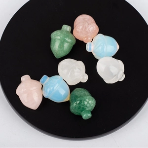 Natural crystal pine cone pendants in various gemstones displayed on a black stand