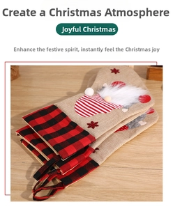 Three rustic linen Christmas stockings with gnome figures on light wood surface