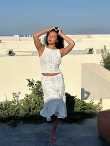 Ensemble blanc deux pièces avec haut en tricot sans manches et jupe en dentelle ajourée