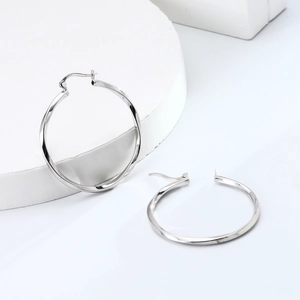 Macro shot showing the S925 hallmark on minimalist silver twisted hoop earrings