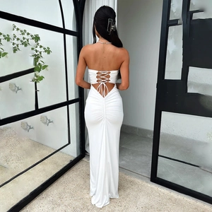 Detail of white backless maxi dress featuring criss-cross straps and ruched back detailing