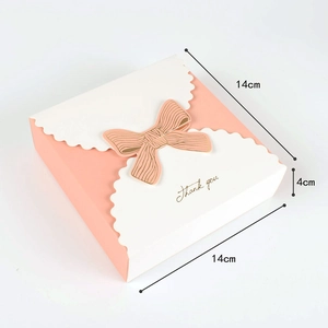 Detail of pink and white gift box with bow and gold Thank You text for candies