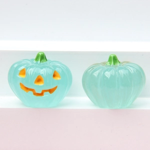 Close-up of translucent light blue Halloween pumpkin ornaments with a jack-o-lantern face