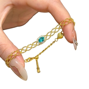 Gold French retro bracelet featuring an oval teal zircon with a halo of white diamonds