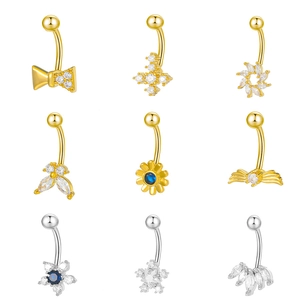 Collection of nine copper and zircon belly rings in gold and silver with various charms