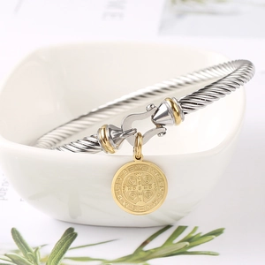 Detail of St. Benedict medal on a two-tone twisted cable bracelet in 18K gold finish