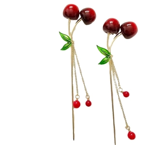 Elegant gold cherry hair stick with red fruit tassels and green leaves on white background