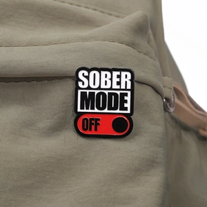 Detailansicht der Sober Mode Off Emaille-Anstecknadel an einer khakifarbenen Stofftasche