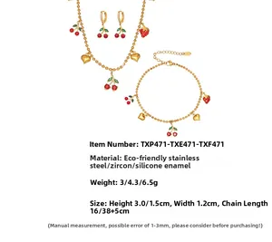 Détail d'un ensemble de bijoux plaqués or PVD avec breloques cerise, fraise et cœur
