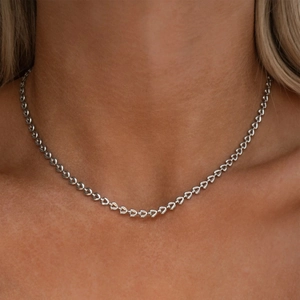 Dettaglio della collana a catena con cuori vuoti indossata dal modello per fit