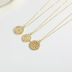 Vintage gold coin pendant necklaces with cross relief designs for women on white backdrop